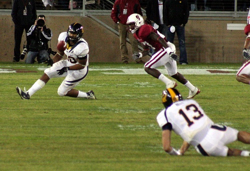 photo image of tight end catching pass from a quarterback who`s been knocked to the ground